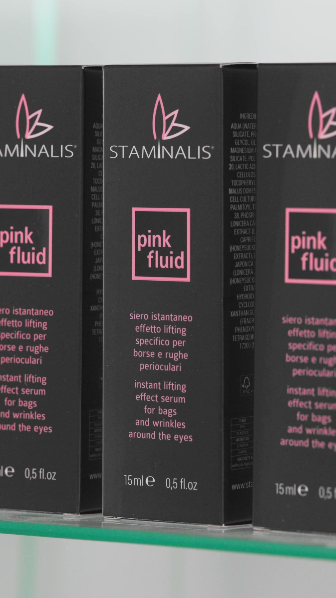 Confezioni del siero Pink Fluid in fila su uno scaffale.